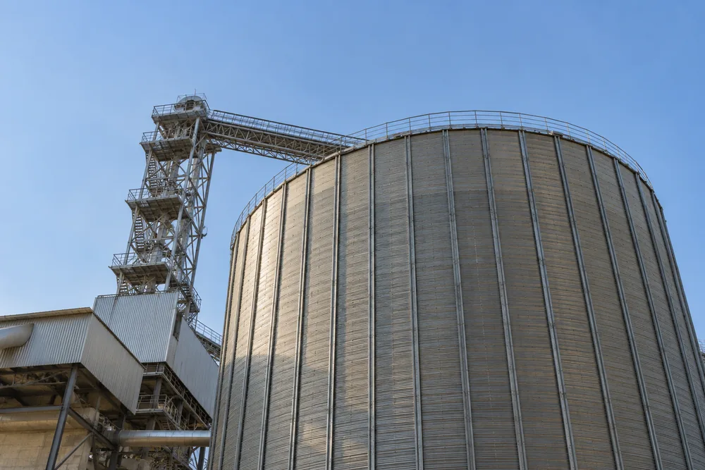 Steel storage silo against a pale blue sky